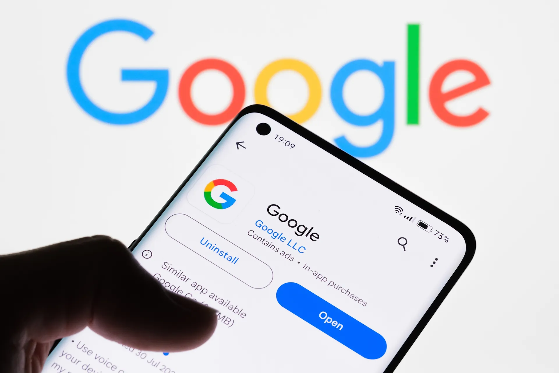 Google -App na obrazovce smartphonu s logem Google na pozadí