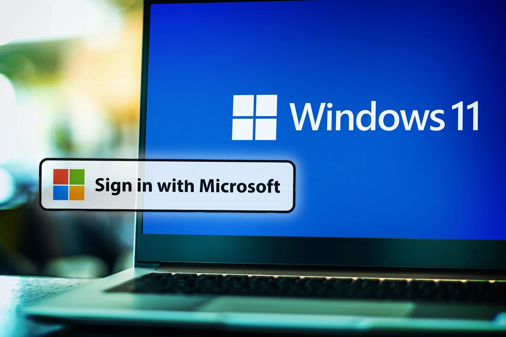 Počítač s notebookem zobrazuje Windows 11 se zprávou "Přihlaste se s účtem Microsoft"