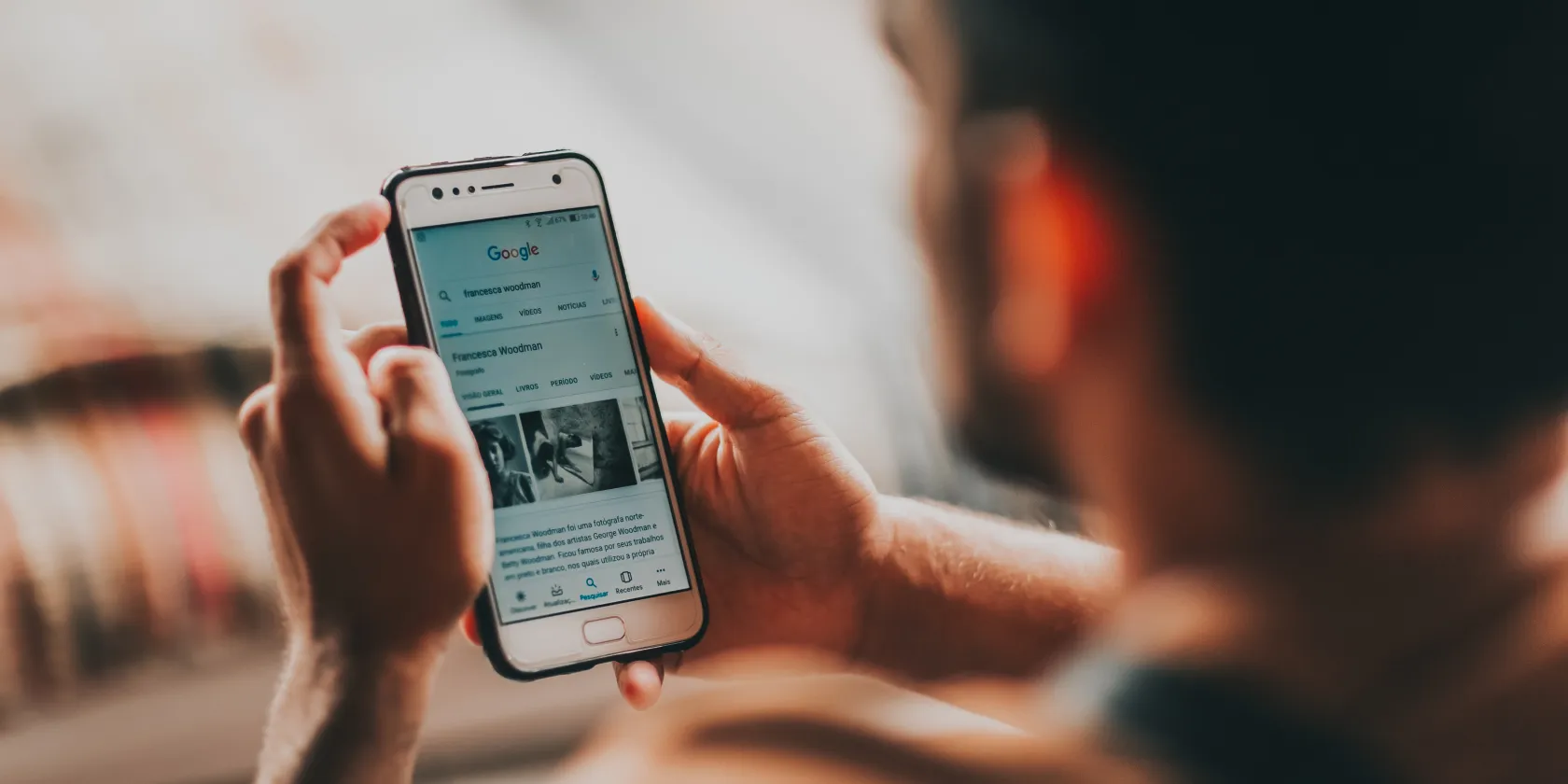 Muž používá Android -Telefoon k procházení internetu