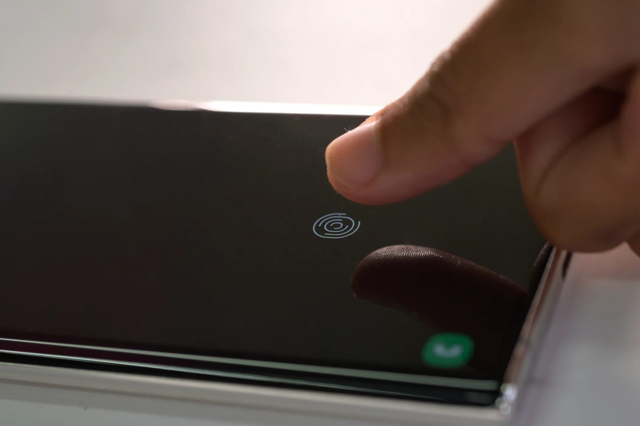 Osoba, která se snaží odemknout svůj galaxiální telefon otiskem prstů