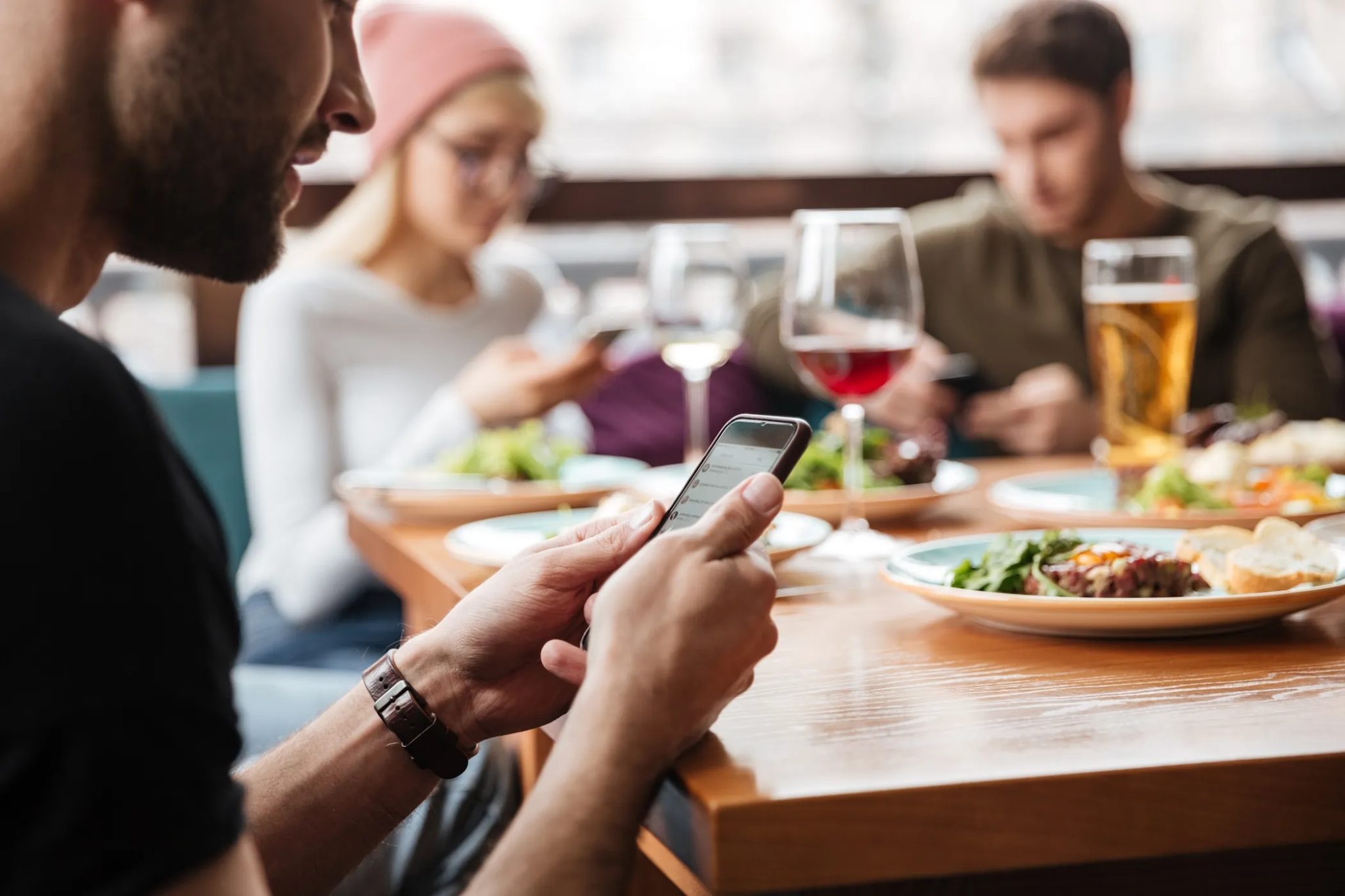 Muž, který používá svůj telefon pro své přátele při jídle