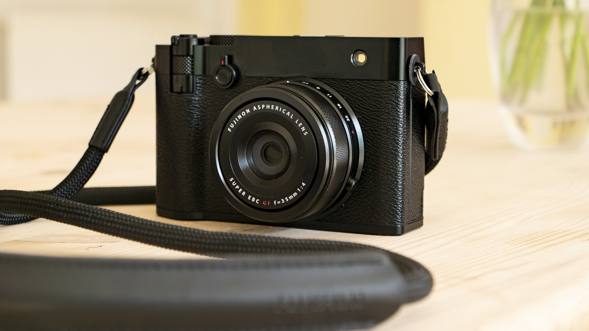 Fotoaparát Fujifilm GFX100RF je zcela černá v rozsahu hluku na dřevěném stole