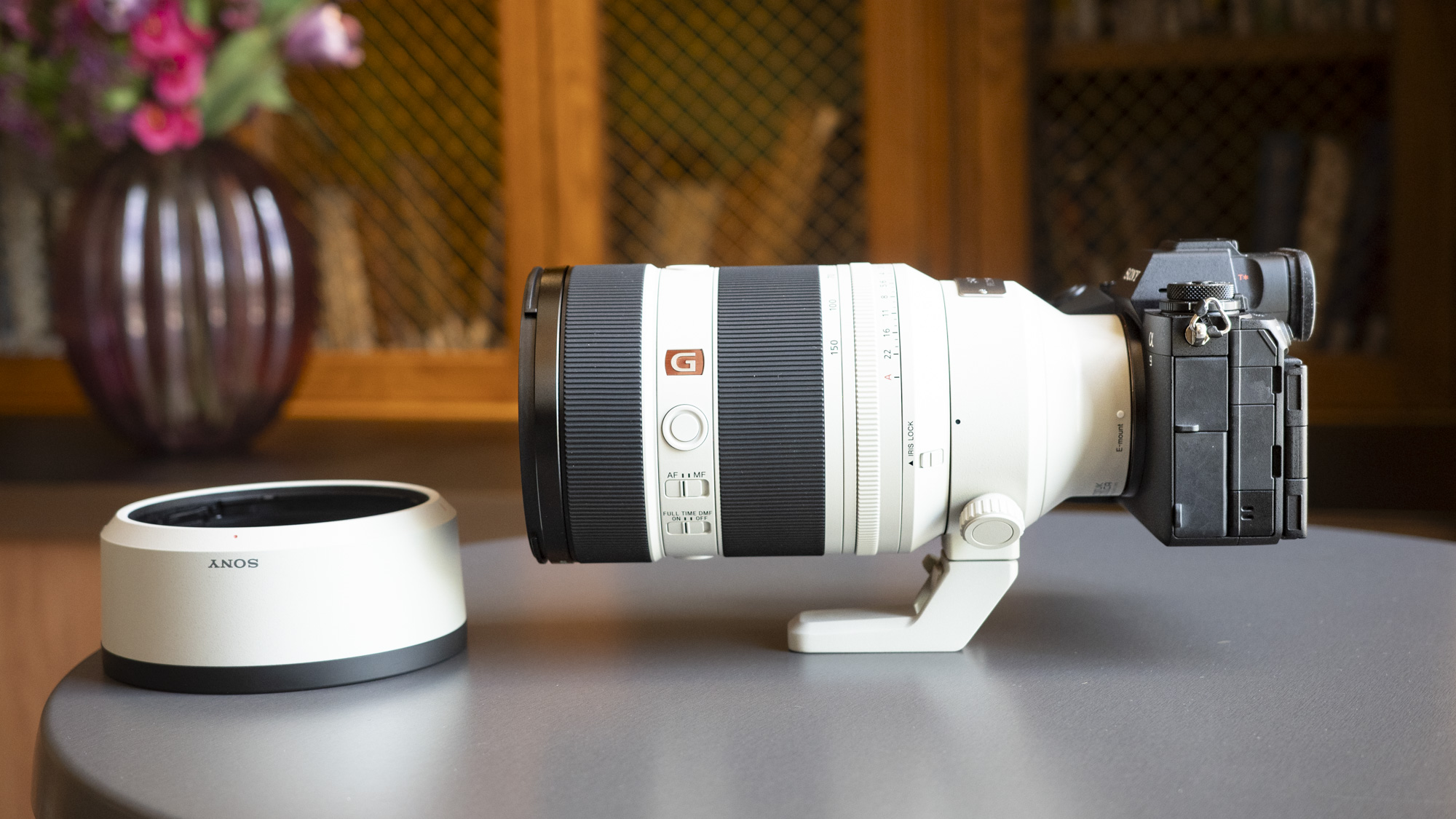 SONY FE 50-150M F2 GM čočka nainstalovaná na kameře Sony A9 III, u stolu